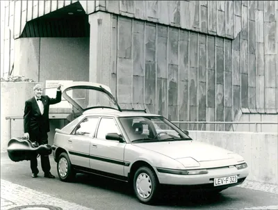 Car, Mazda 323, Lower middle-sized class, Limousine, model year 1990, red,  diagonal from the front, standing, upholding Stock Photo - Alamy